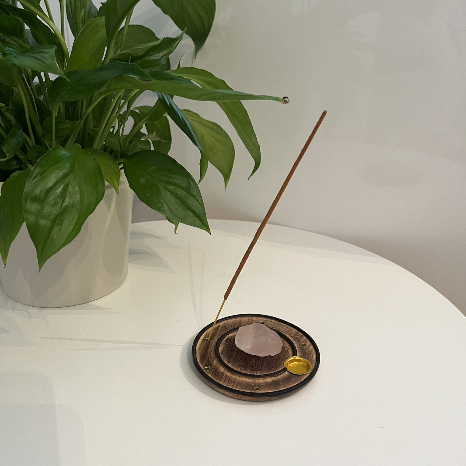 Runder Räucherstäbchenhalter aus Holz mit Rosenquarz Edelstein, von oben fotografiert auf hellem Leinenhintergrund, cocoeco Wien